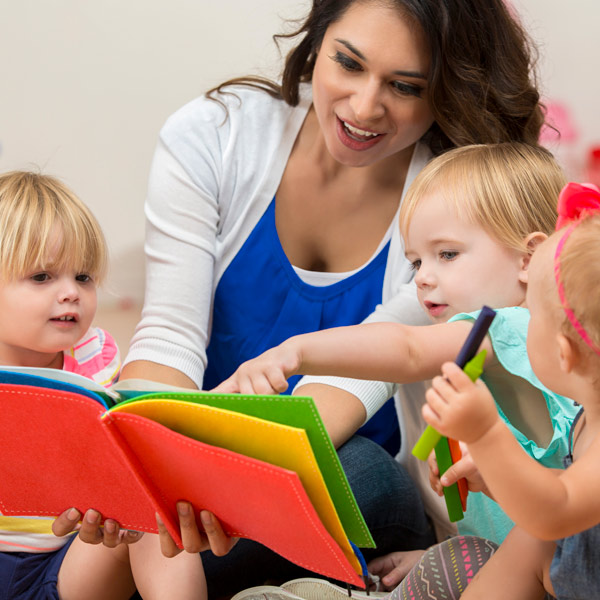 teacher reading a book to small children